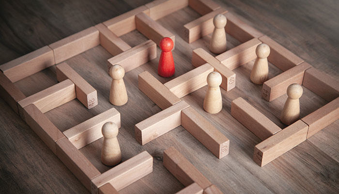 Dekorativt arkivbillede af trælabyrint med små træfigurer